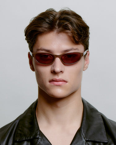 Lilla smal cat-eye A.Kjærbede solbriller med lilla glas - forfra på herre
