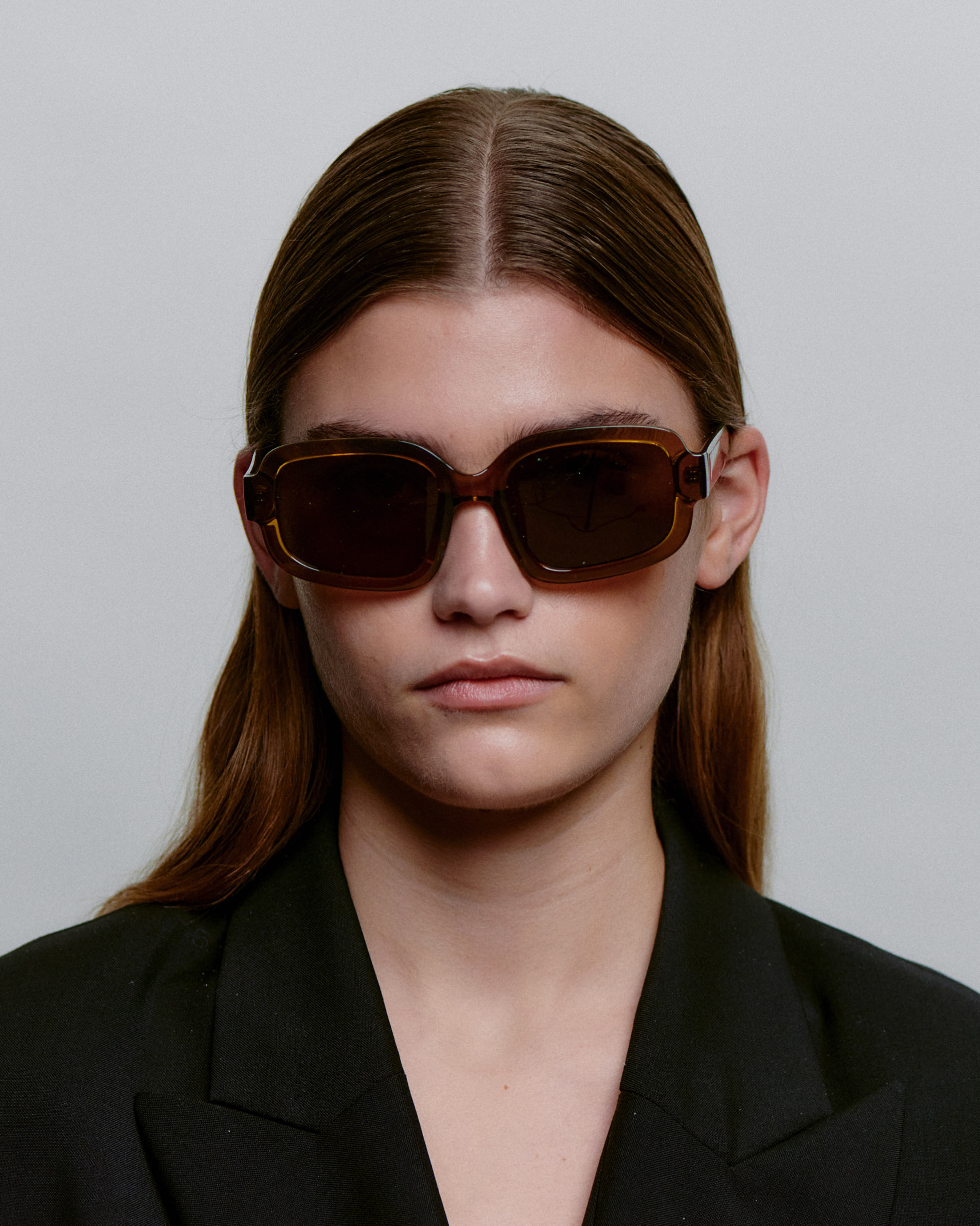 Store brune firkantet A.Kjærbede solbriller med mørk glas - foran på kvindemodel