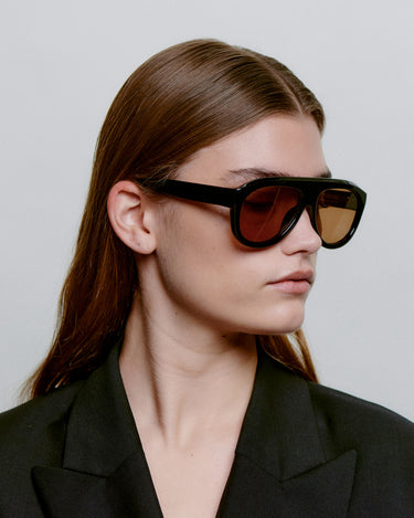 Store sorte aviator A.Kjærbede solbriller med brun glas - sideprofil kvindemodel